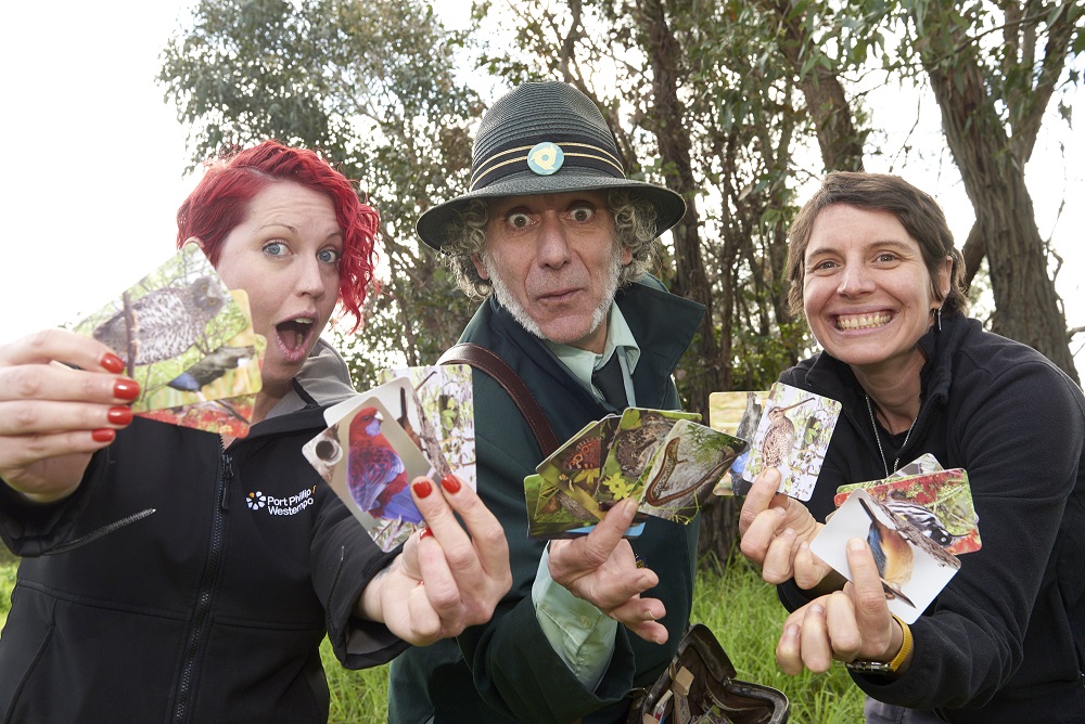 Three people holding animal cards